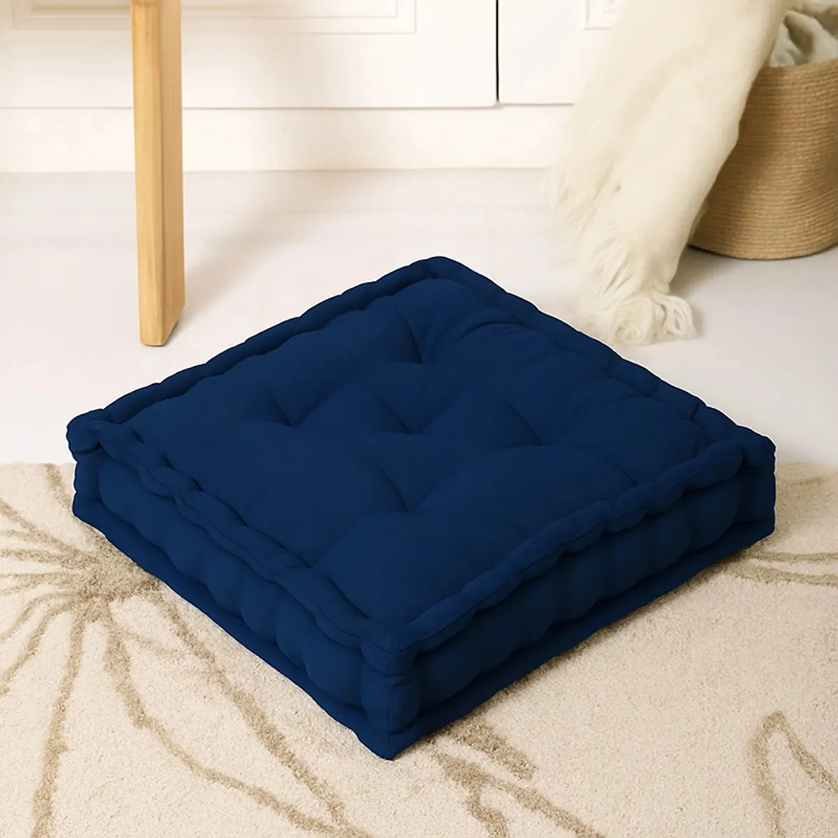 Navy blue square tufted floor cushion placed on a patterned rug