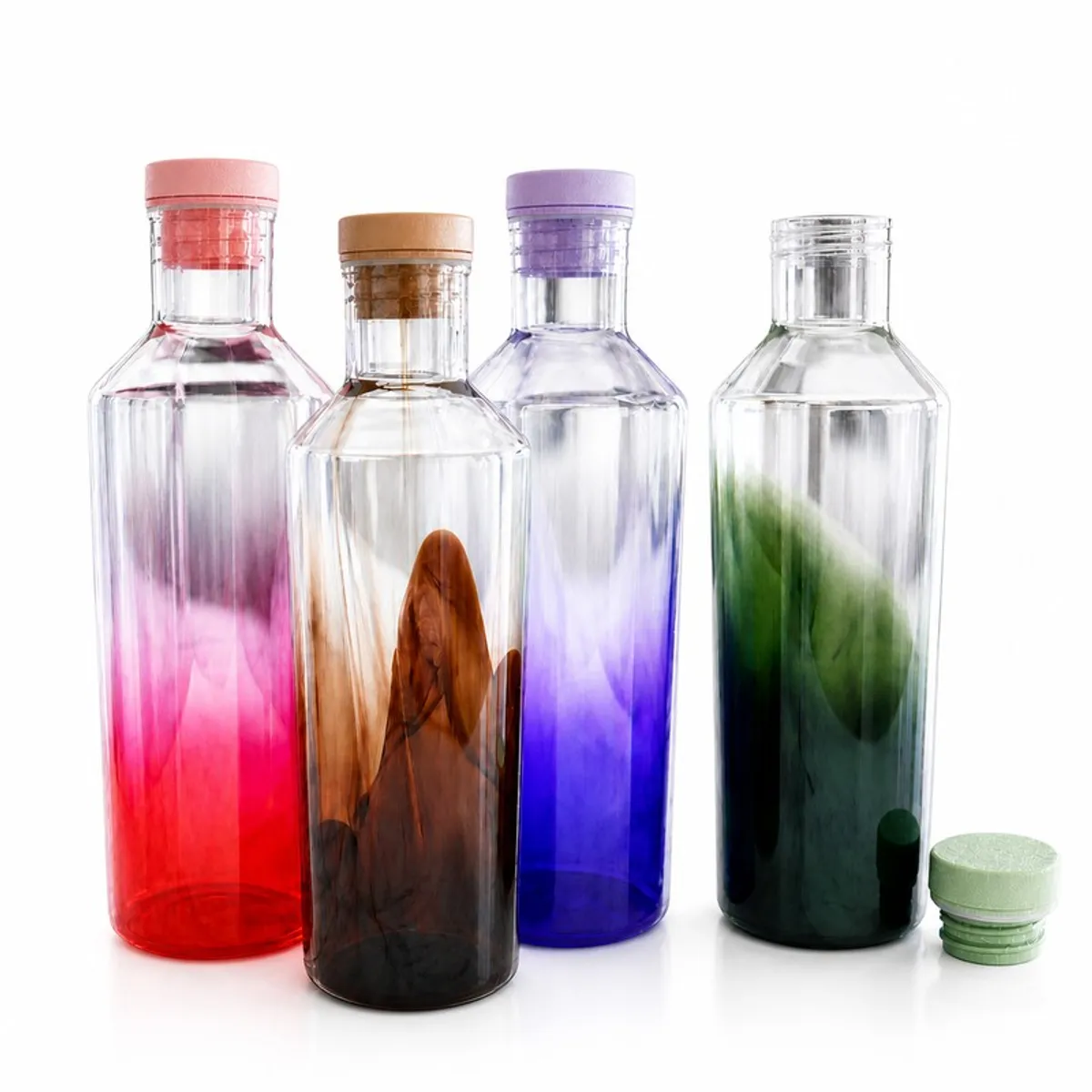 Four glossy red, brown, purple and green bottles on a white background