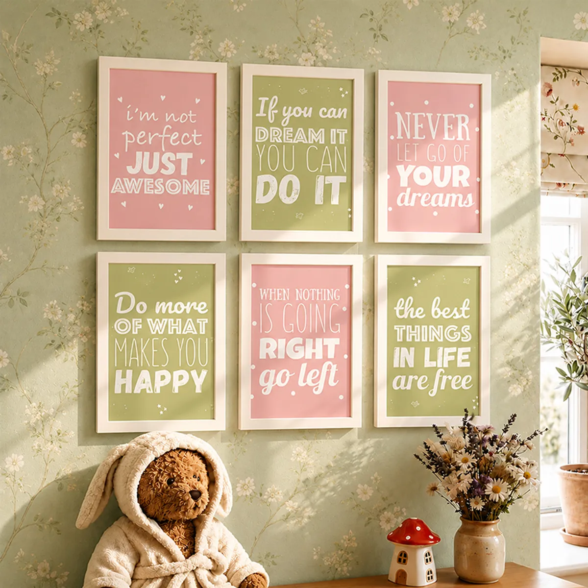 Six framed pink and green typography prints displayed on a soft green floral wallpaper wall.
