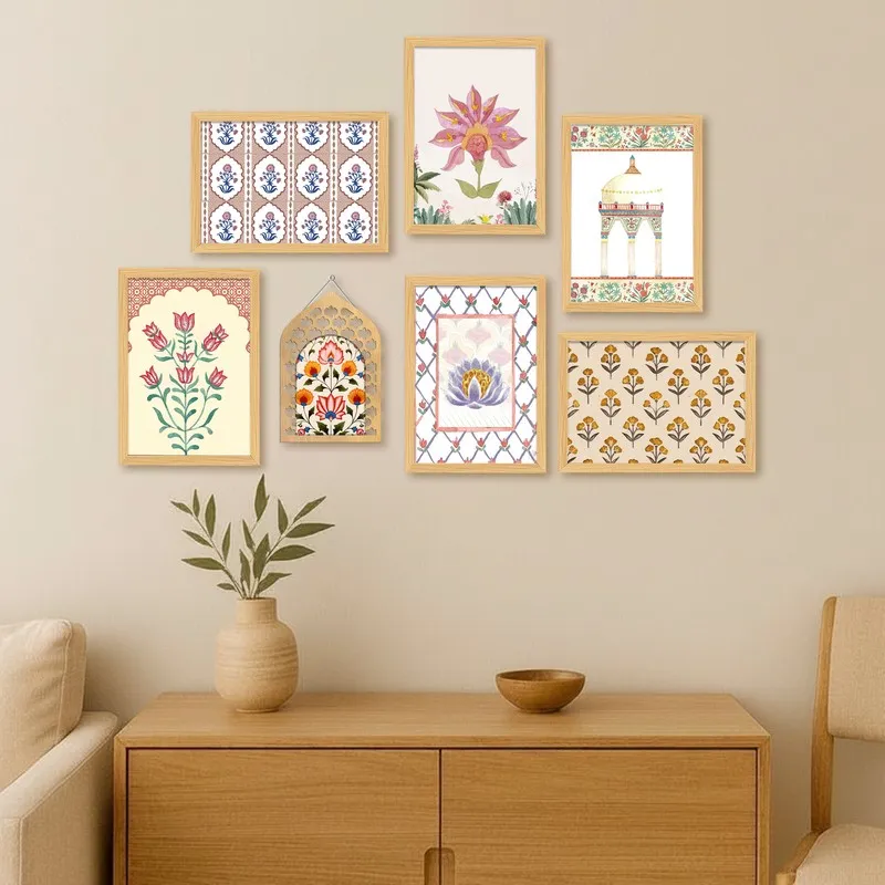 Seven framed decorative artworks arranged above a wooden console in a living room