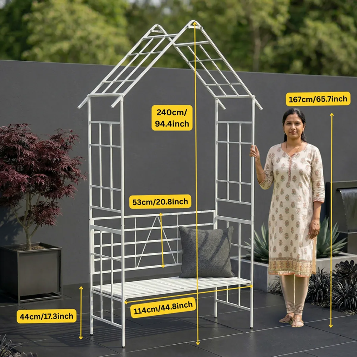 White peaked garden structure shown beside a person for scale