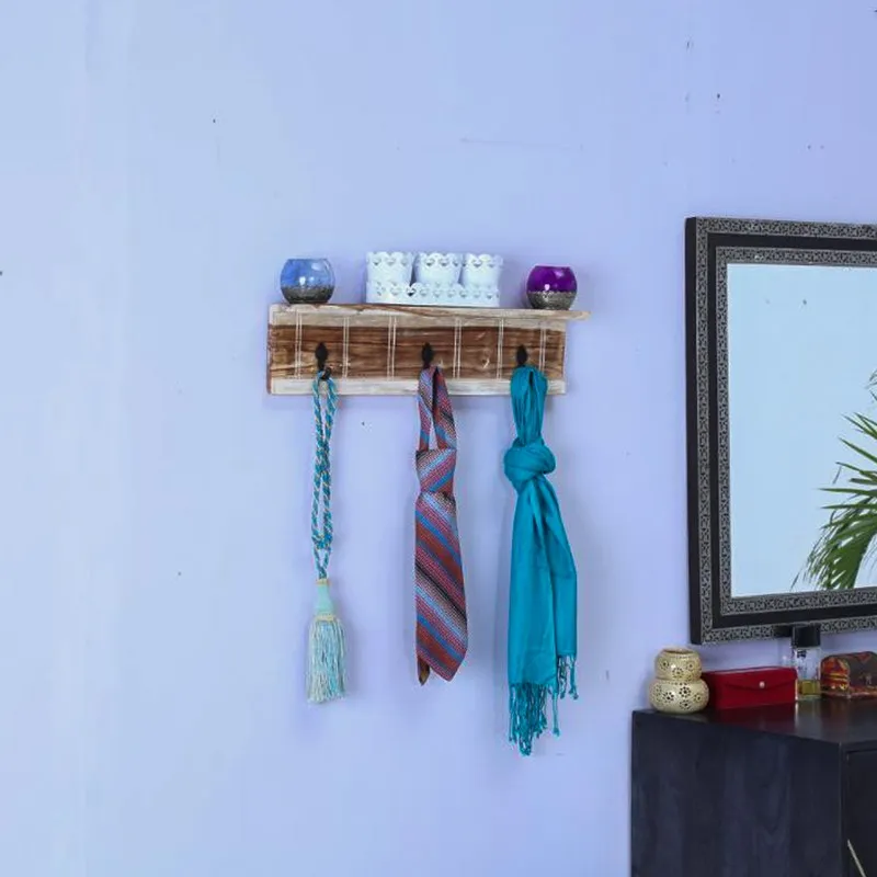Wooden wall key holder mounted on a wall with scarves hanging from three hooks