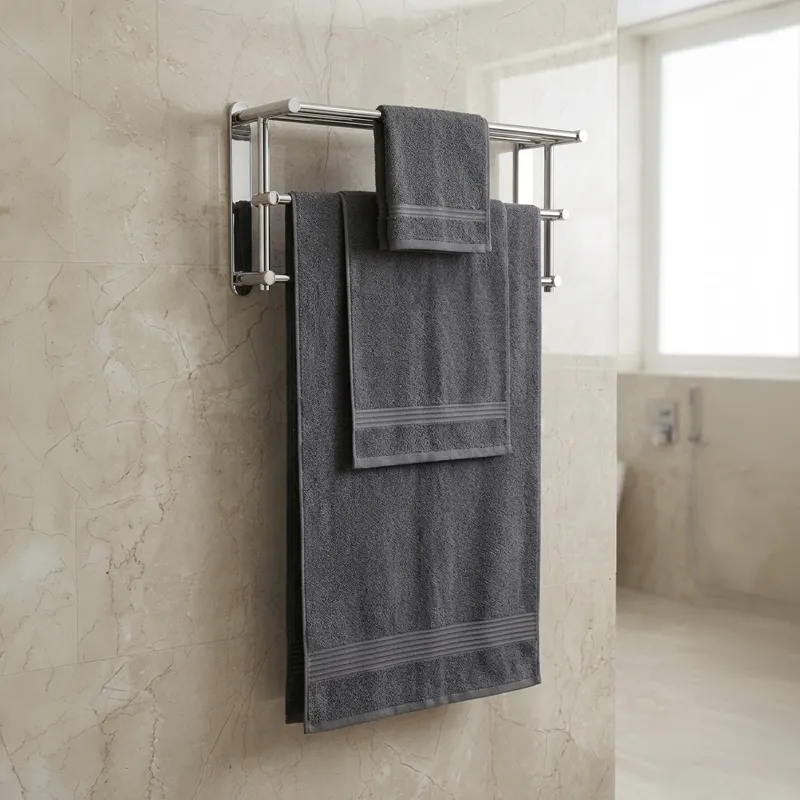Charcoal grey bath, hand and face towels hanging on a metal rack in a bathroom