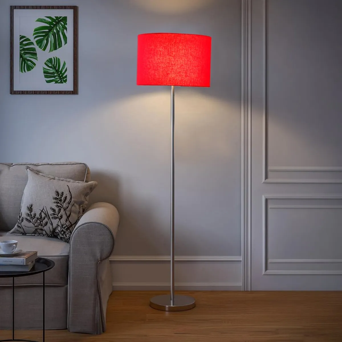 Red shade floor lamp beside a grey sofa in a neutral living room