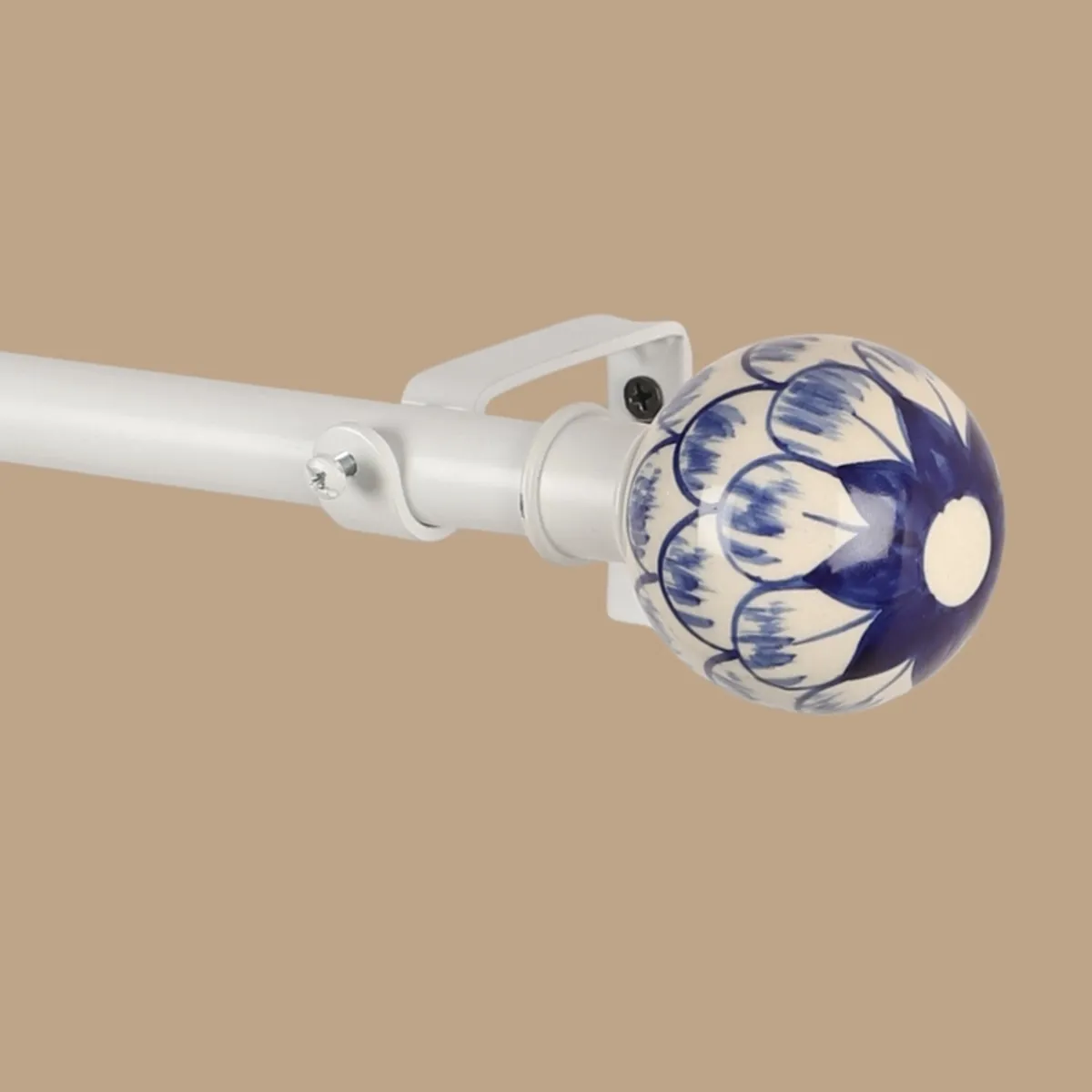Close-up of a white curtain rod with a blue floral round finial