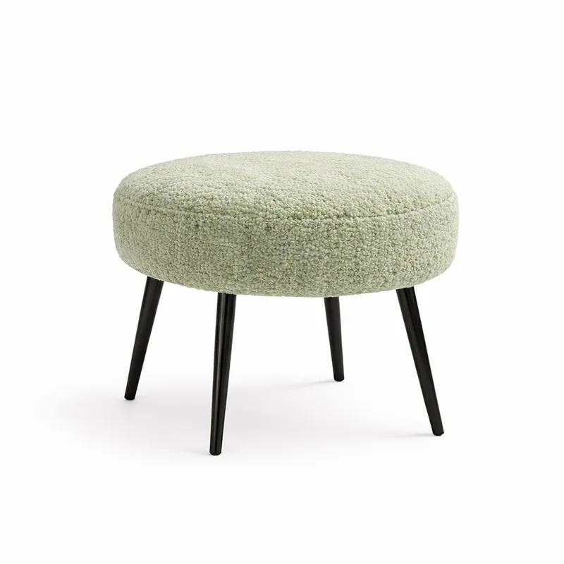 Round sage bouclé stool with four black legs on a white background