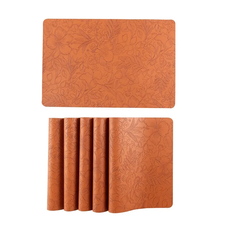 One orange table mat with rolled matching mats below on white background