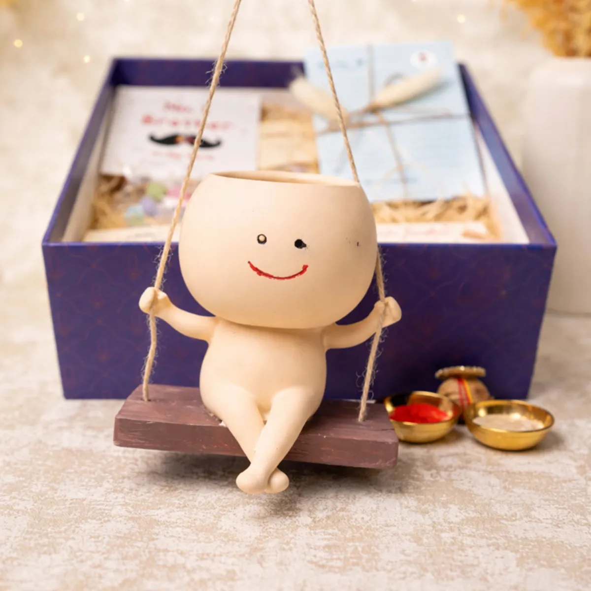 Smiling character planter displayed on a wooden swing with the hamper behind it