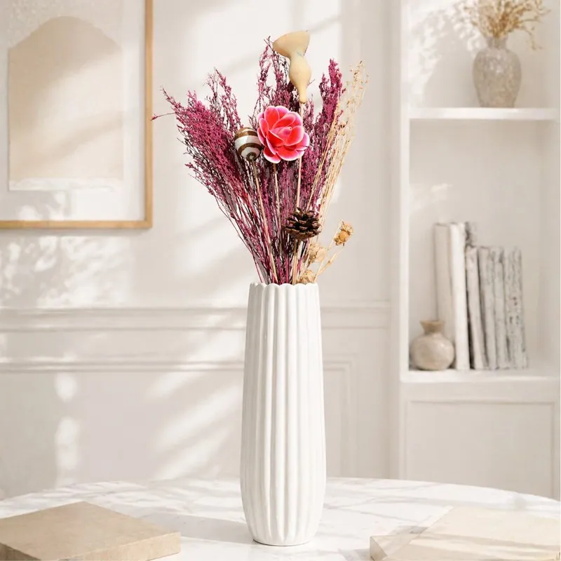 Pink dried flower bouquet styled in a tall fluted white vase