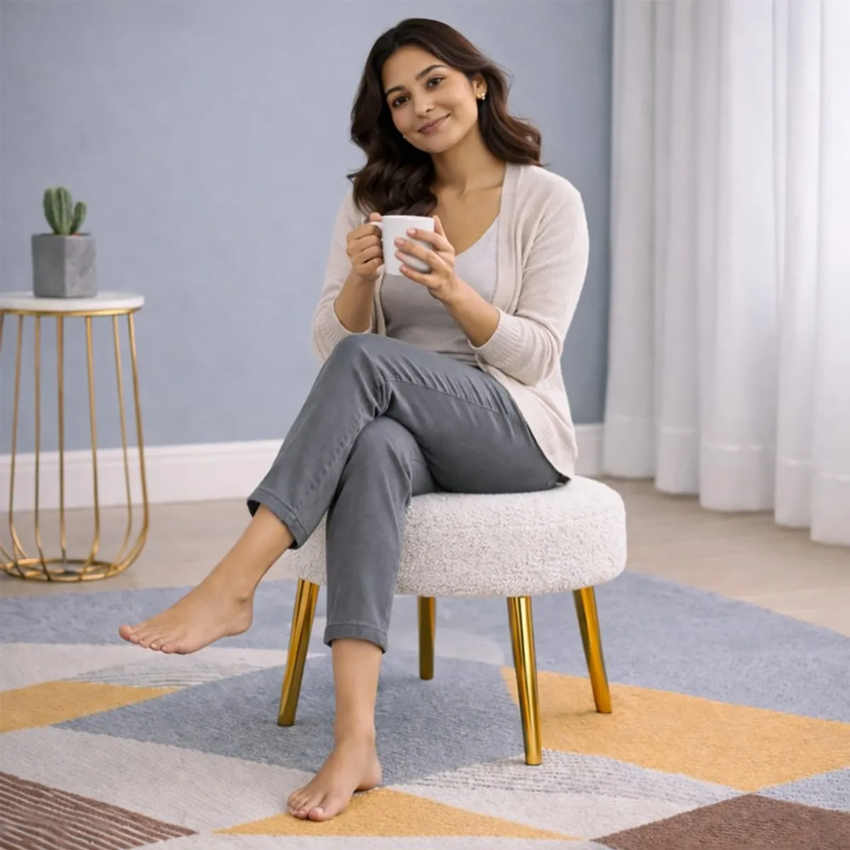 Person seated on a white round bouclé stool with gold legs