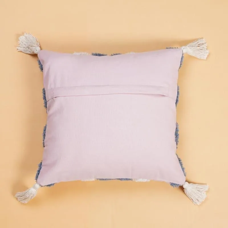 Back view of a pink cushion cover with tassels at the corners