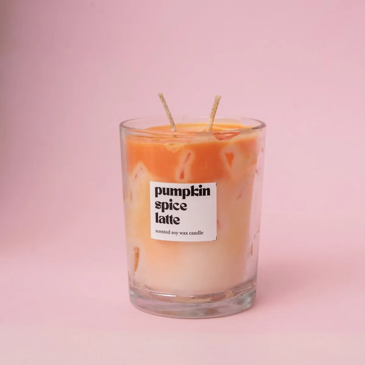 Close-up of orange-and-cream pumpkin spice candle in a glass jar