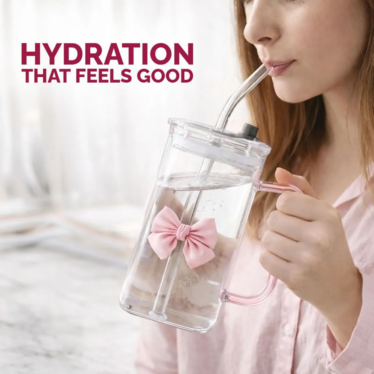 Person holding clear tumbler with pink bow and handle, filled with water