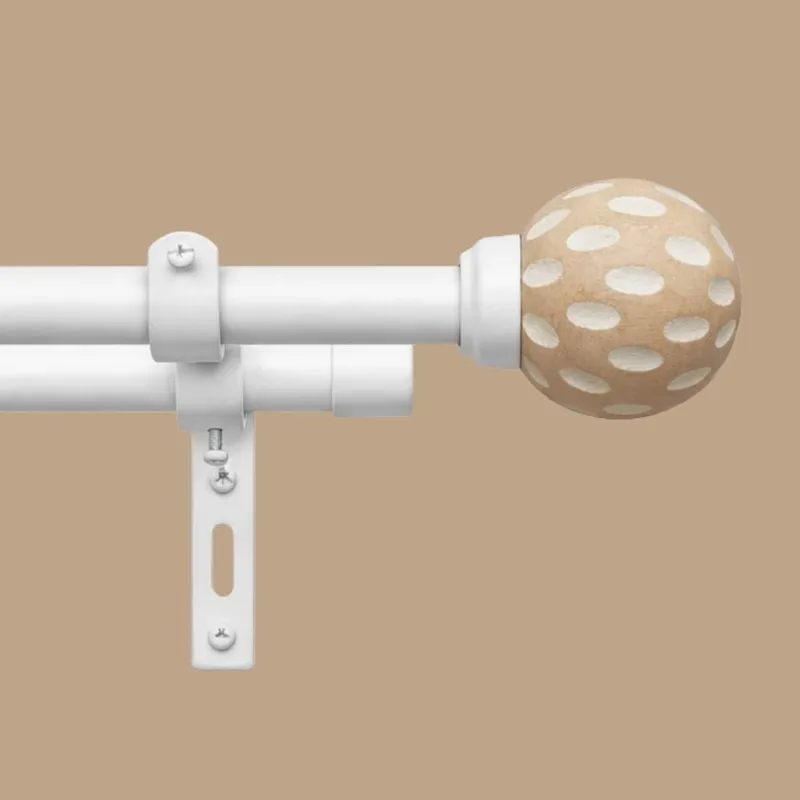 Close-up of the white rod, bracket and brown polka-dot round finial.