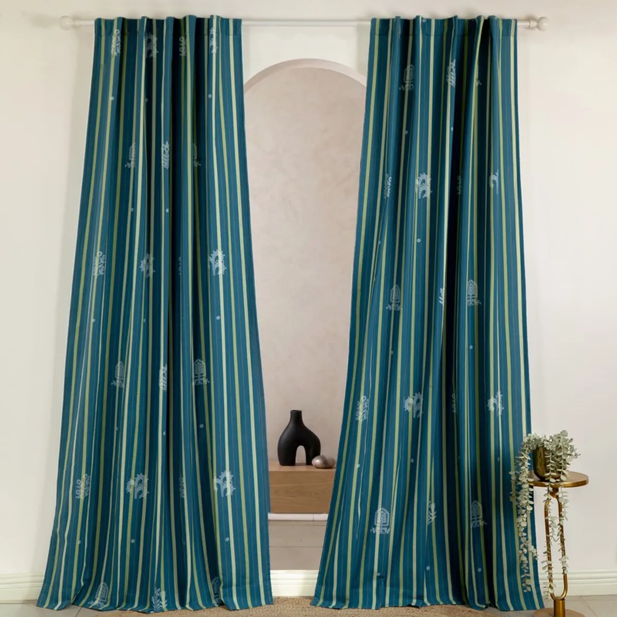 Pair of blue and olive striped curtains hanging from a rod in a room