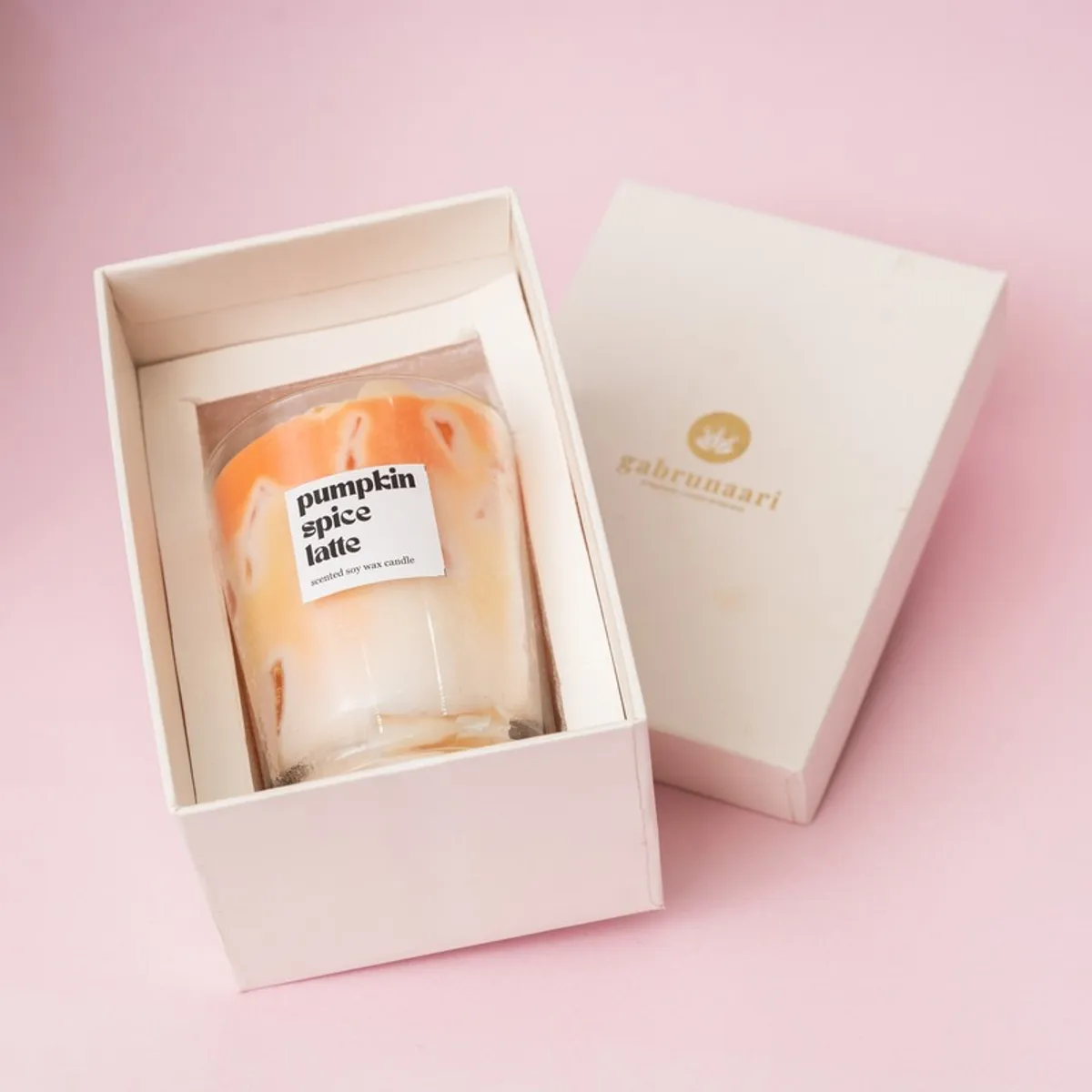 Orange-and-cream candle shown inside an open presentation box