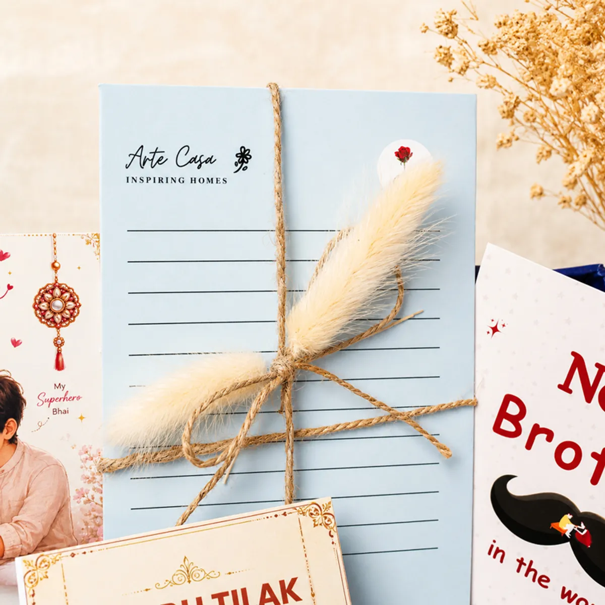 Close-up of a blue rakhi note card tied with twine and dried grass.