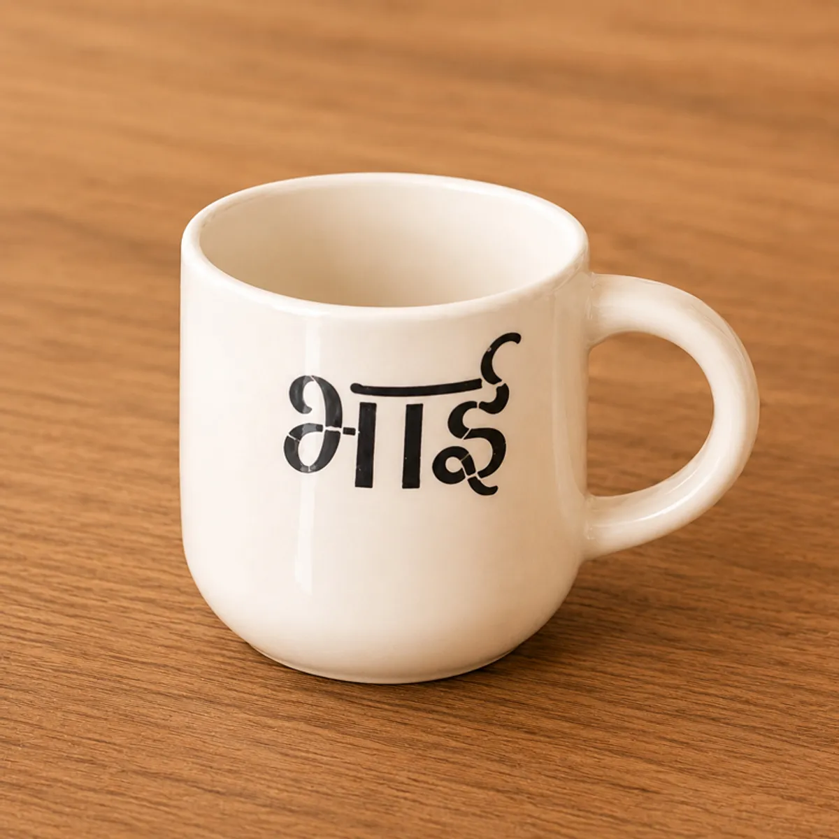 Close-up of a cream ceramic mug with a black Devanagari design
