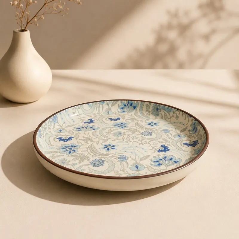 Side angle of a ceramic dinner plate with blue floral pattern and brown rim
