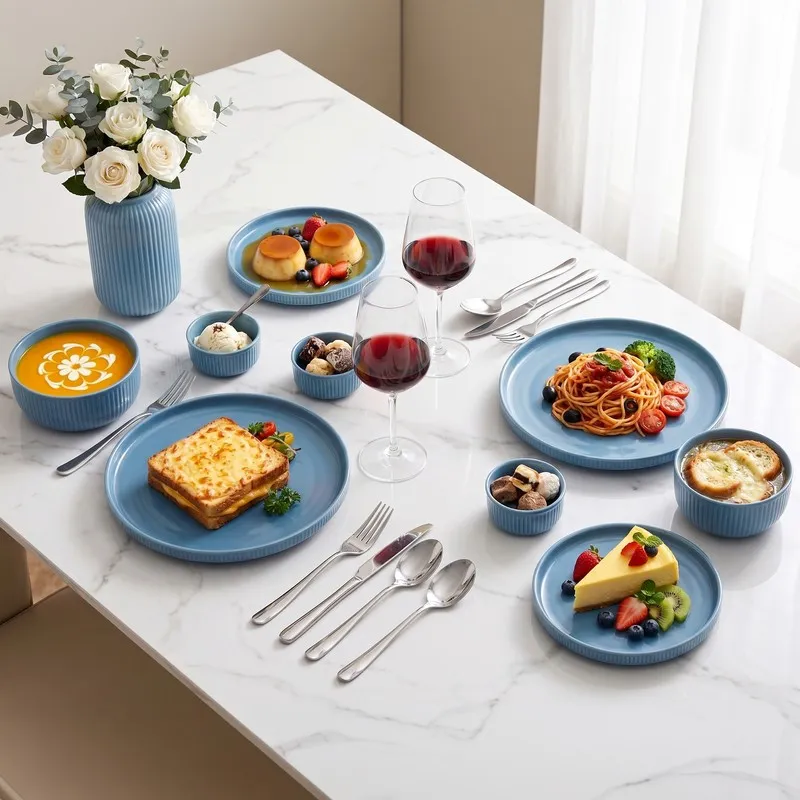 Blue dinner set laid out on a dining table with plated food and ribbed bowls