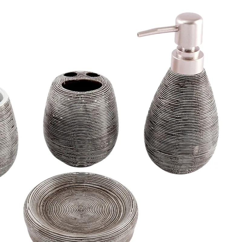 Close-up of black ribbed soap dispenser, holder and round soap dish