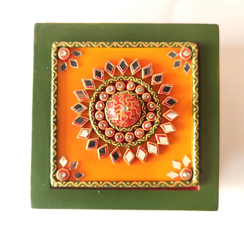 Top view of square orange and green lid with raised decorative detailing