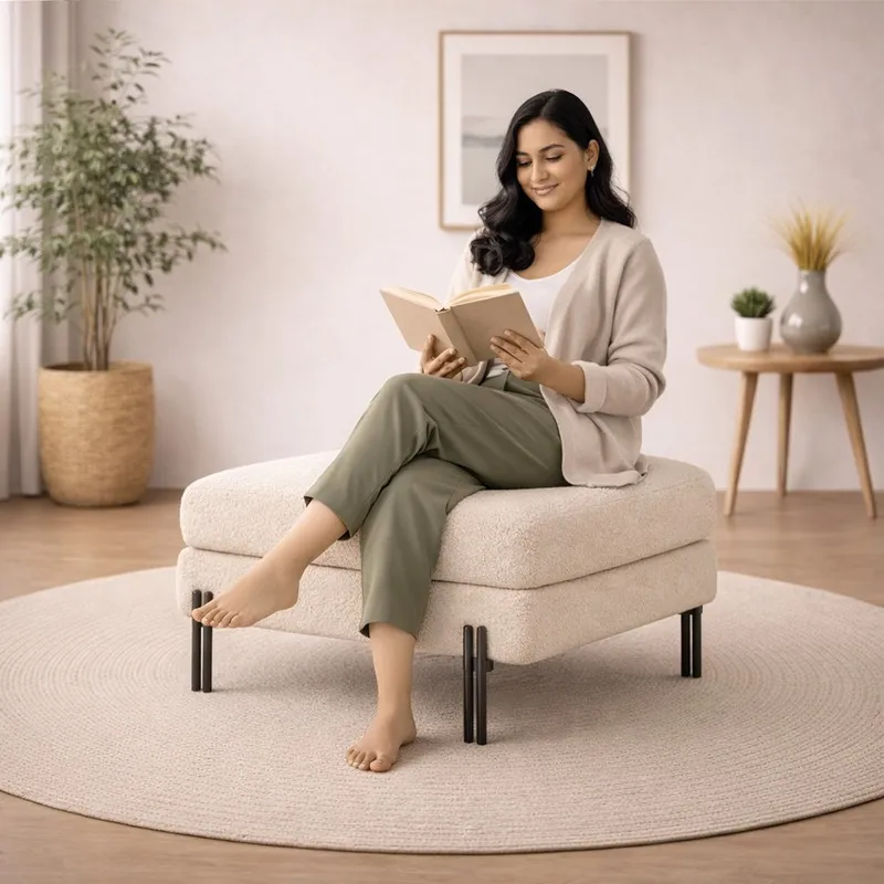 Person seated on a white bouclé ottoman with black metal legs