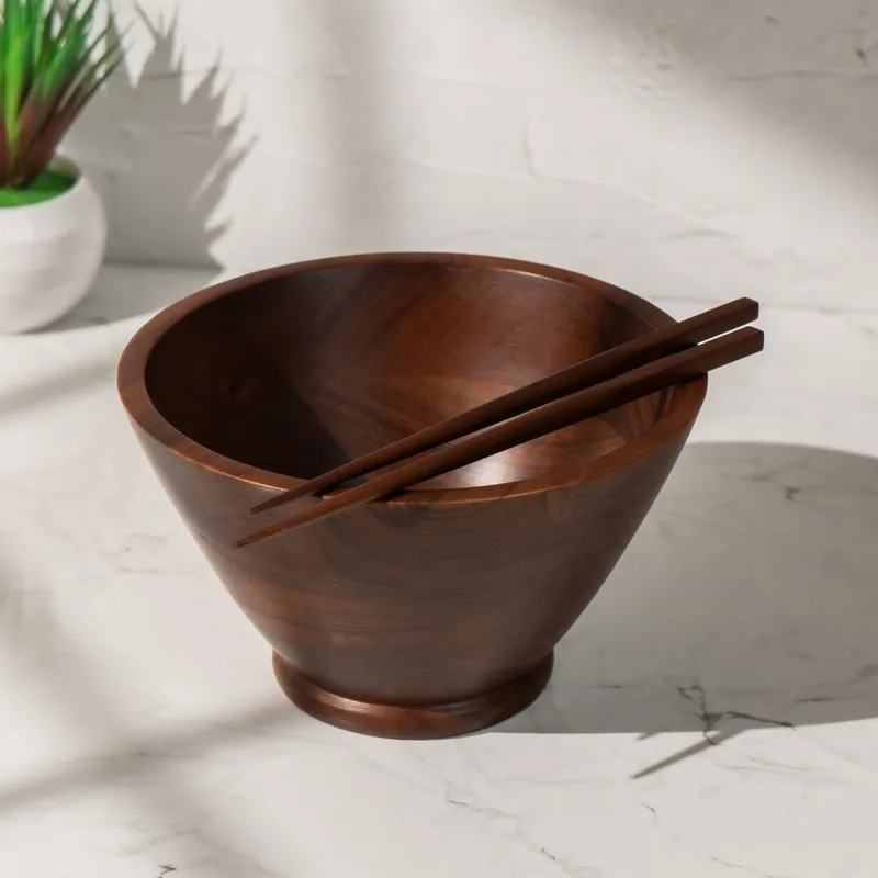 Brown wooden serving bowl with two chopsticks resting across the rim
