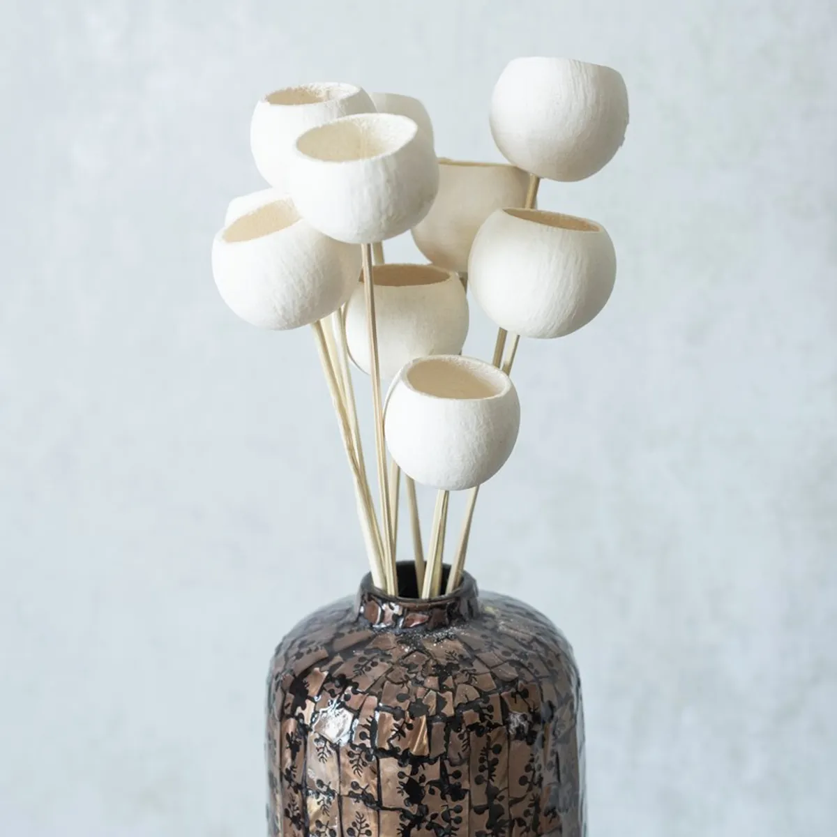 Close-up of white textured bell cup blooms in a decorative vase