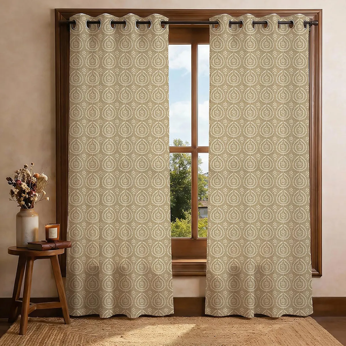 Pair of beige curtains with repeating white motifs framing a large window.