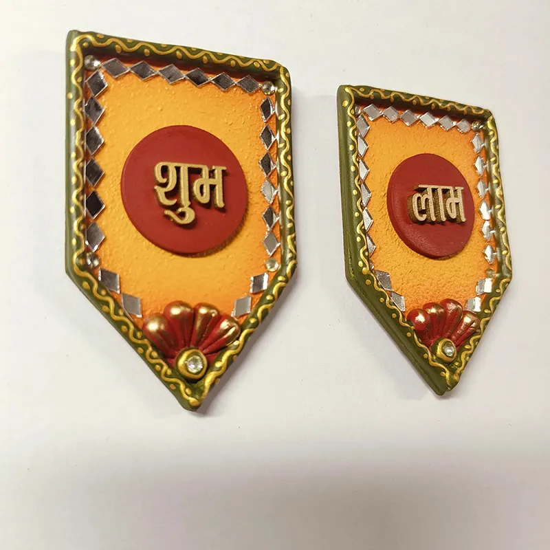 Close-up of two handcrafted Shubh Labh wall accents with ornate detailing