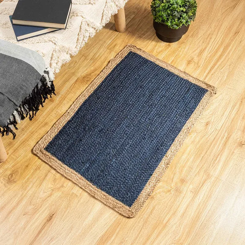 Blue rectangular jute rug with natural border styled on a wooden floor