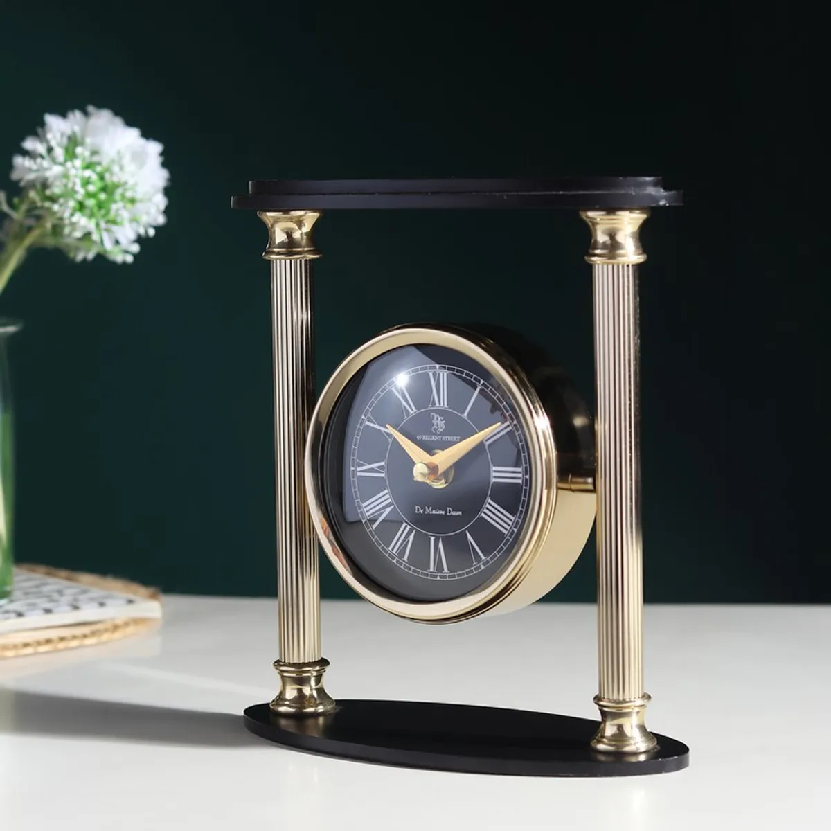 Angled view of gold and black table clock with Roman numeral dial