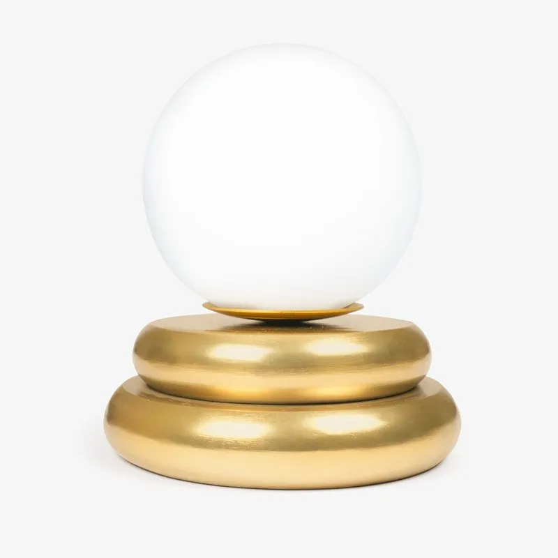 Front view of the white globe lamp with tiered gold base