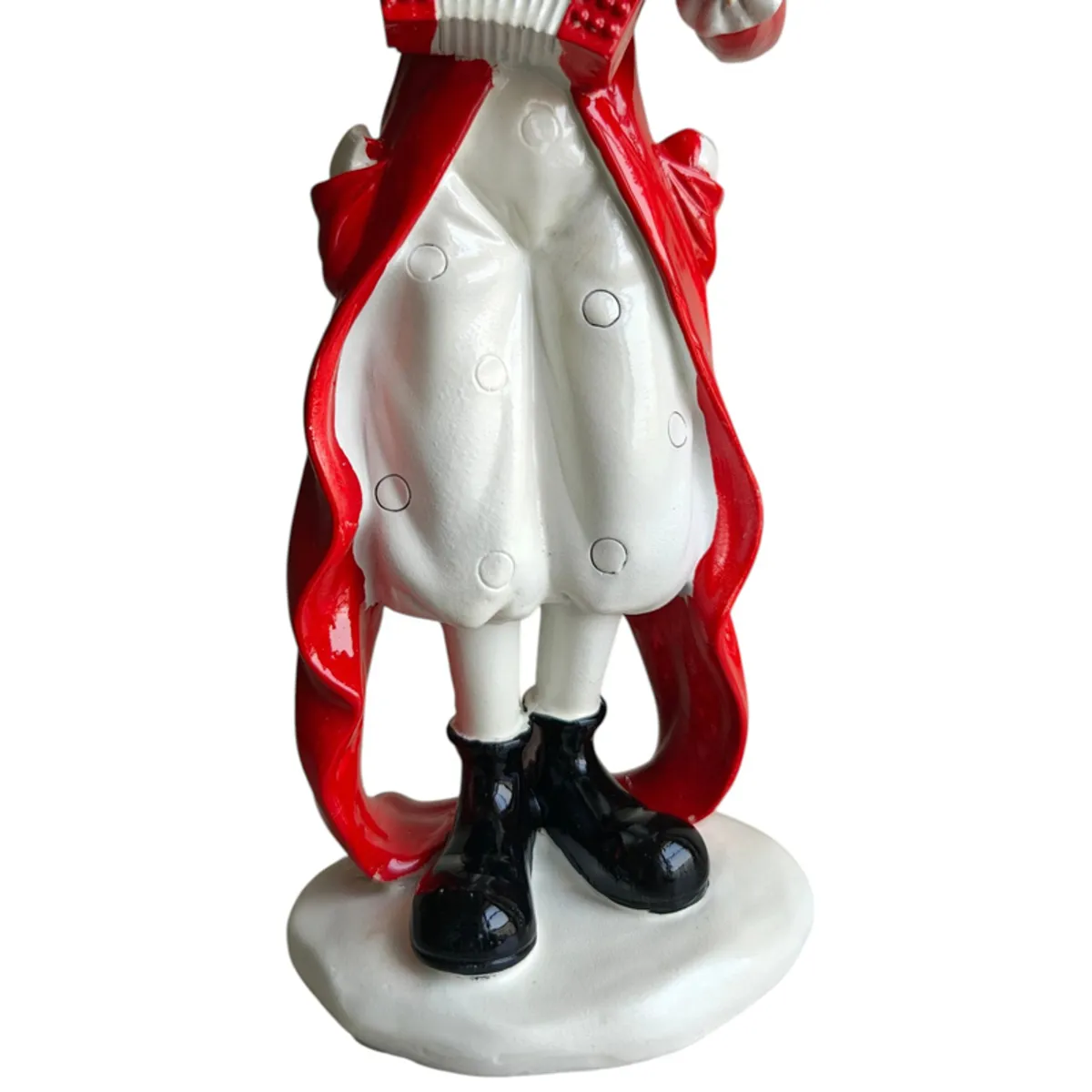 Close-up of the figurine's white costume, black boots and oval base