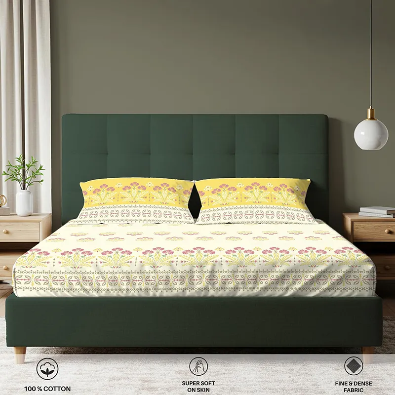 Front view of yellow and off-white floral fitted bedsheet on a bed