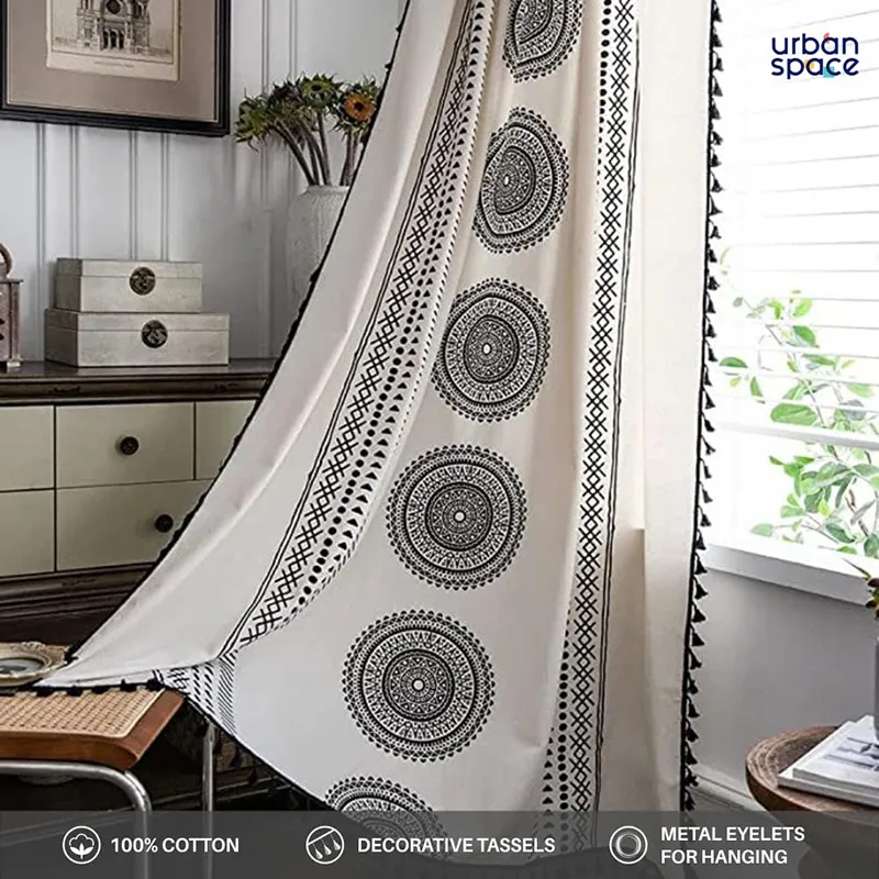 Black and white tasseled curtain draped beside a window in a styled room