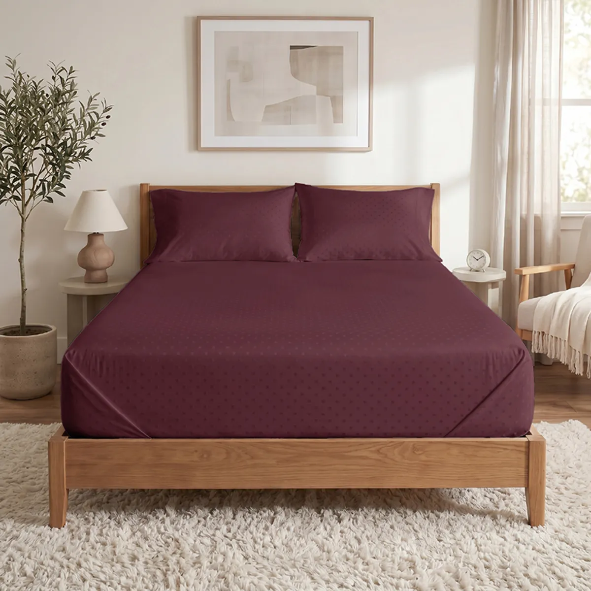 Front view of a maroon Swiss dot duvet cover on a wooden bed