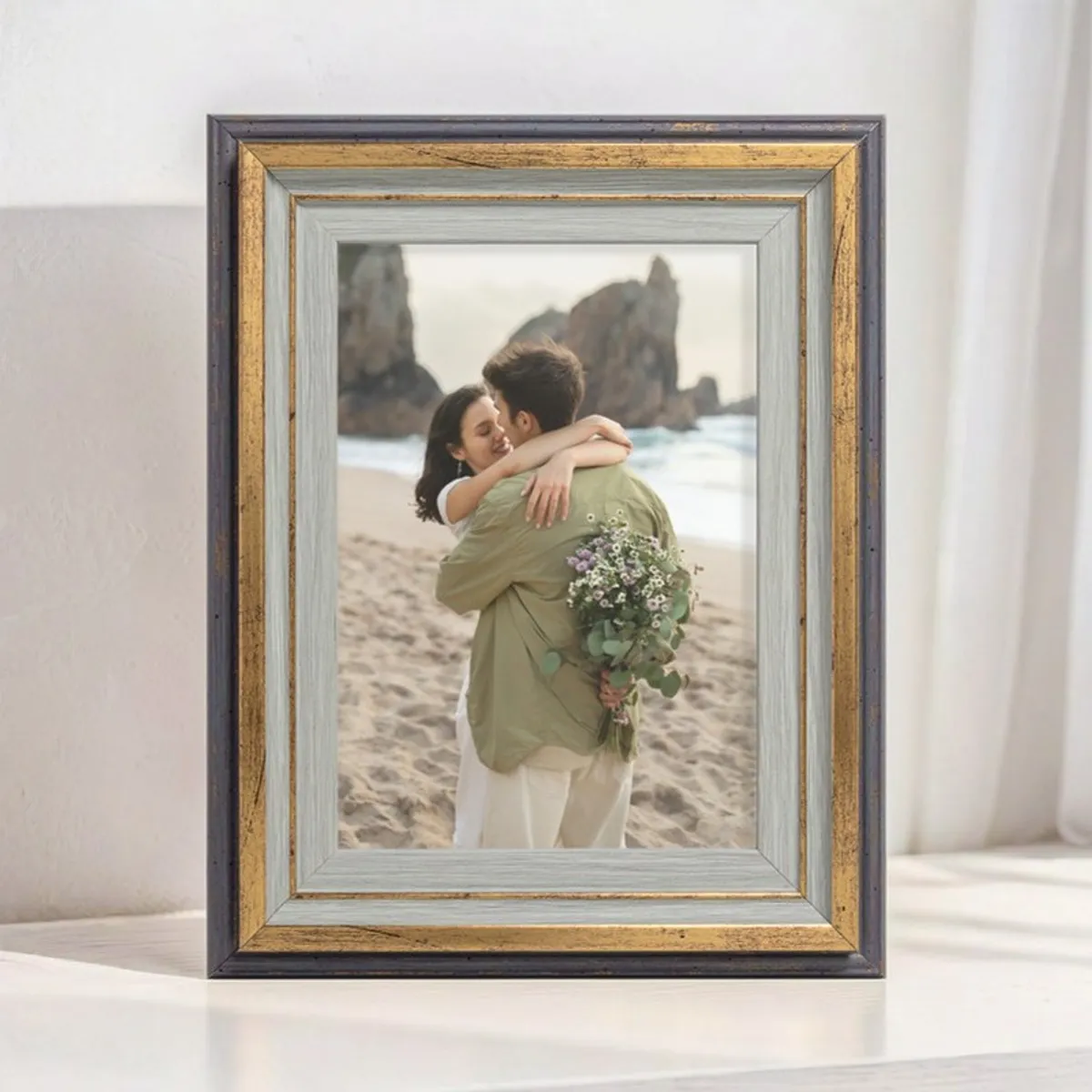 Gold and grey rectangular photo frame styled upright on a tabletop