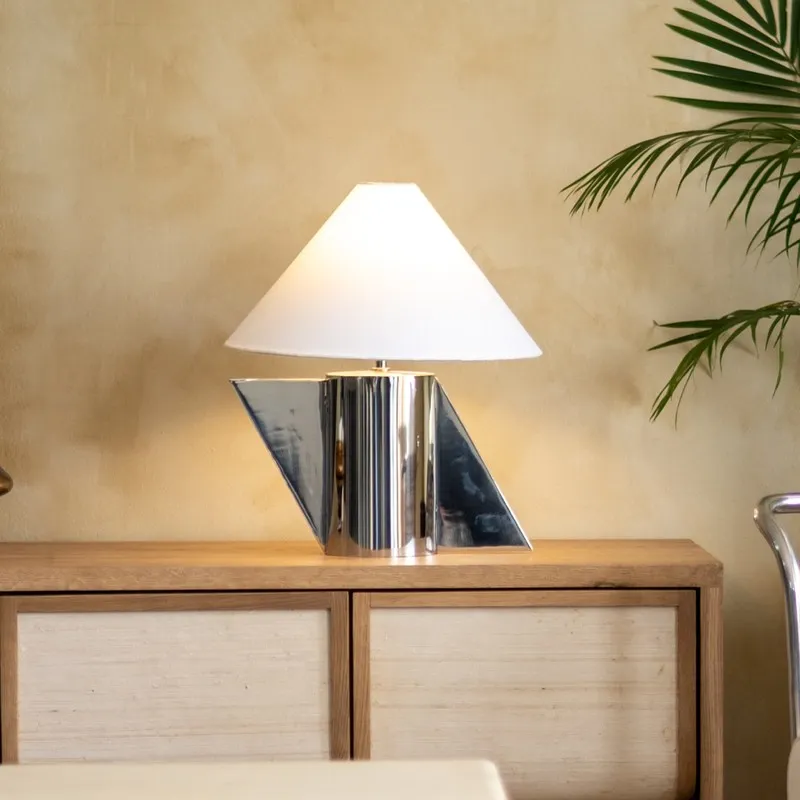 Geometric silver and white table lamp styled on a wooden sideboard