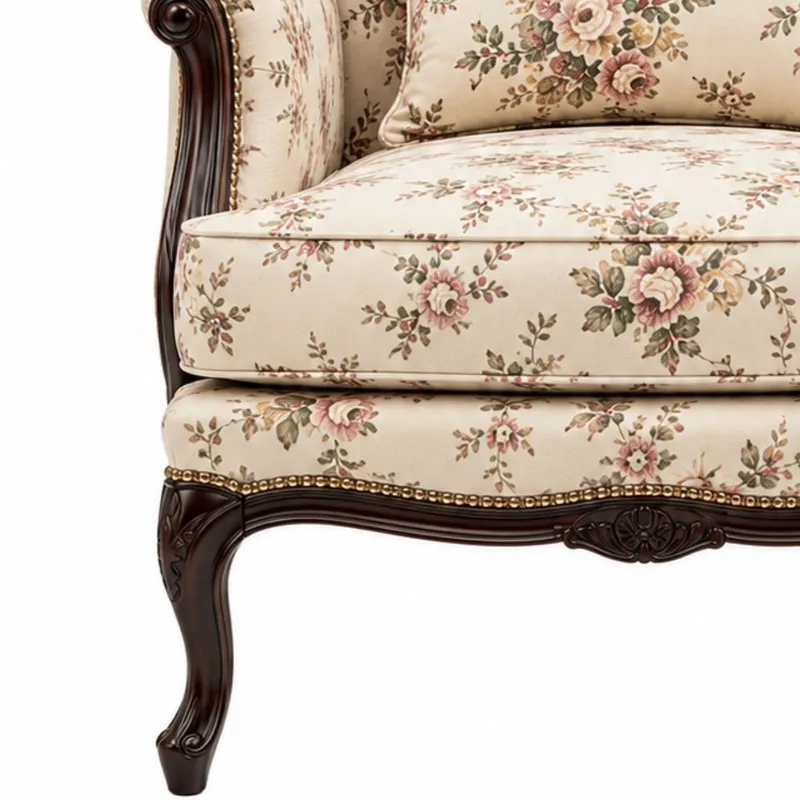 Close-up of floral upholstered seat and carved dark wood leg detail