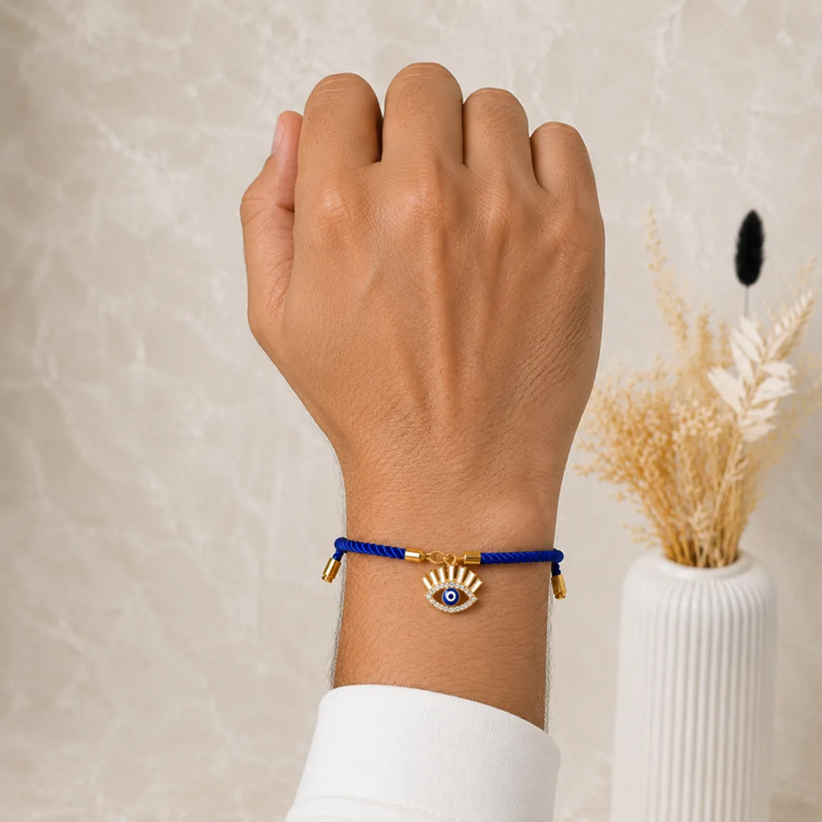 Blue evil eye Rakhi tied around a person's wrist