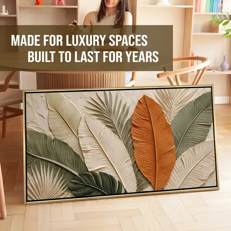Framed tropical leaf canvas artwork leaning on the floor in a room