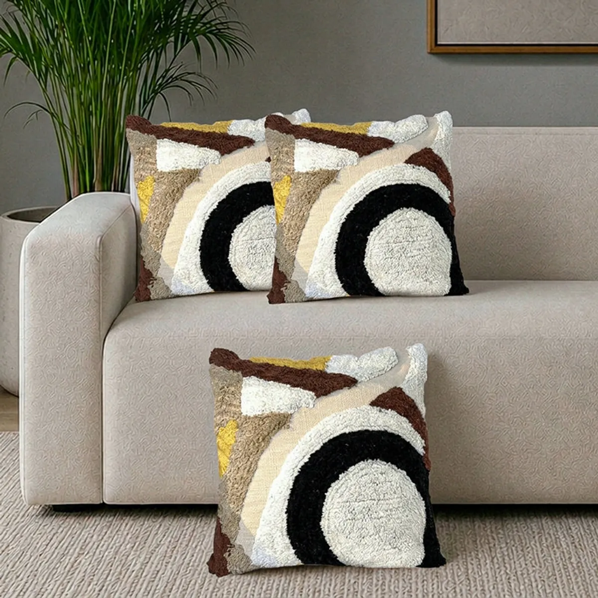 Three tufted geometric cushion covers in brown, black, cream and yellow on a sofa
