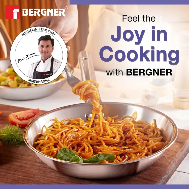 Silver frying pan with spaghetti in a warm kitchen setting