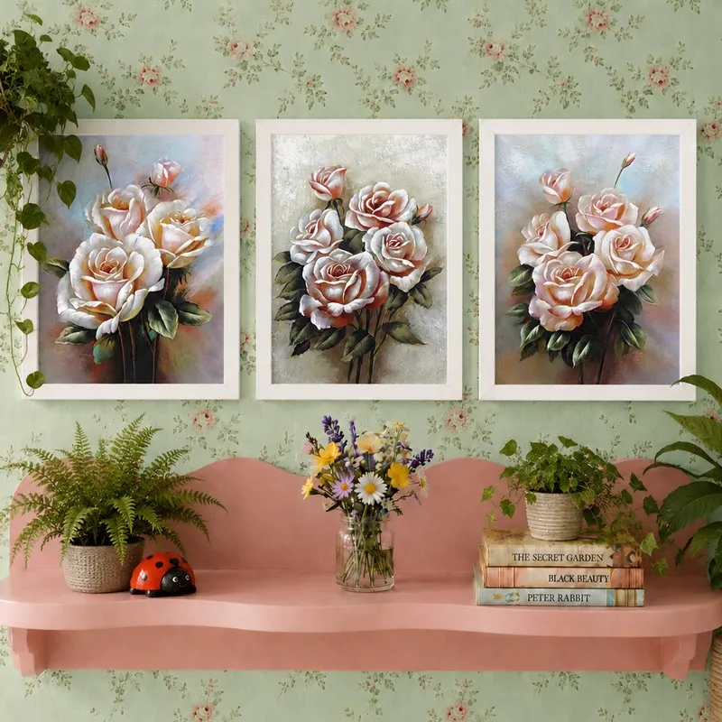 Three white-framed floral wall paintings with pink roses on a pastel wall