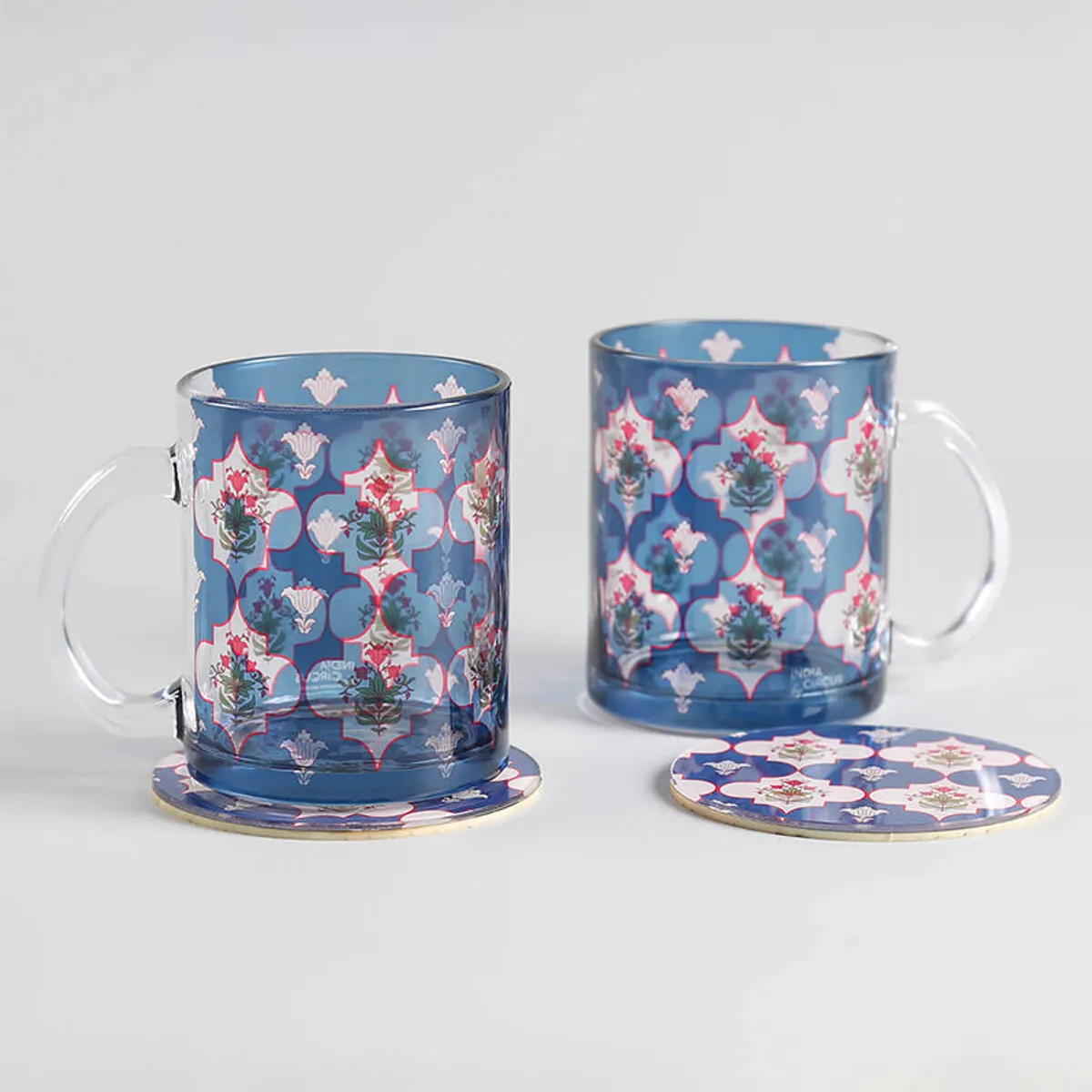 Blue floral glass mugs placed on matching round coasters