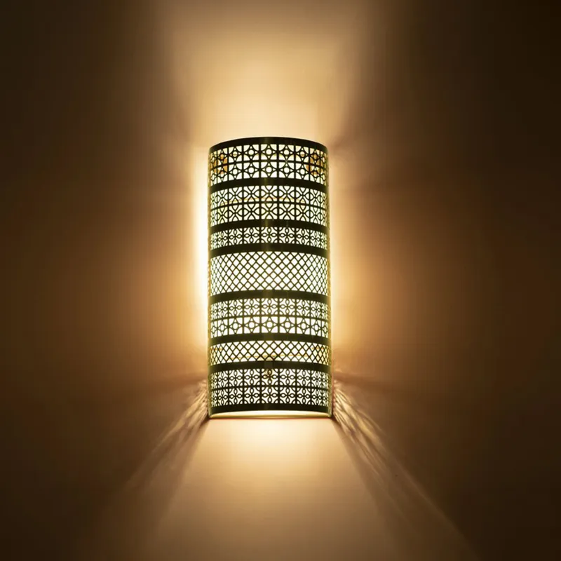 Lit gold lattice wall lamp casting warm light and shadows upward and downward