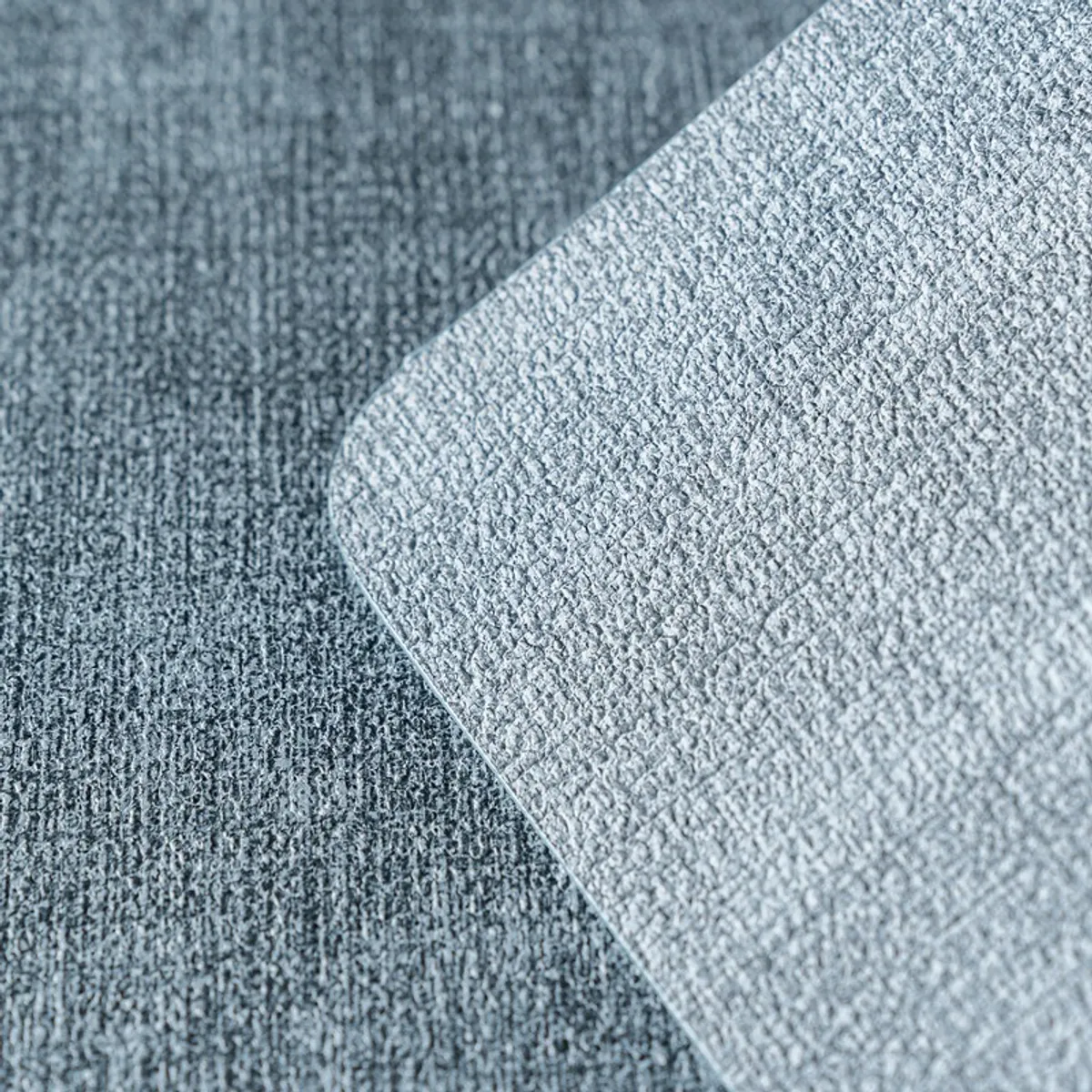 Close-up of the blue mat's woven-look textured surface and rounded corner