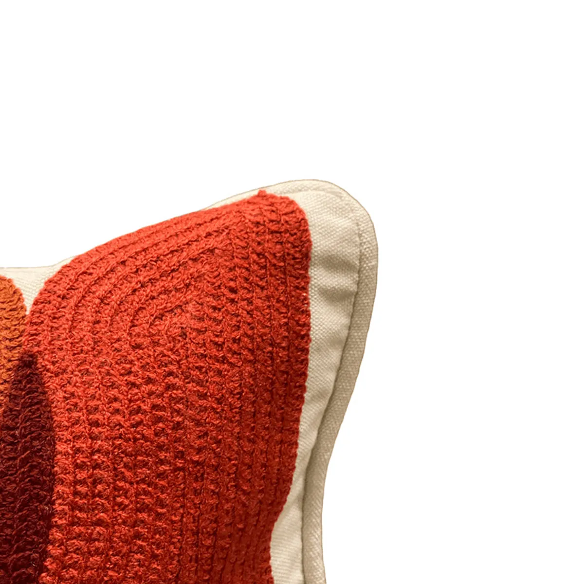 Close-up of the red tufted geometric texture and cream edge of a cushion cover